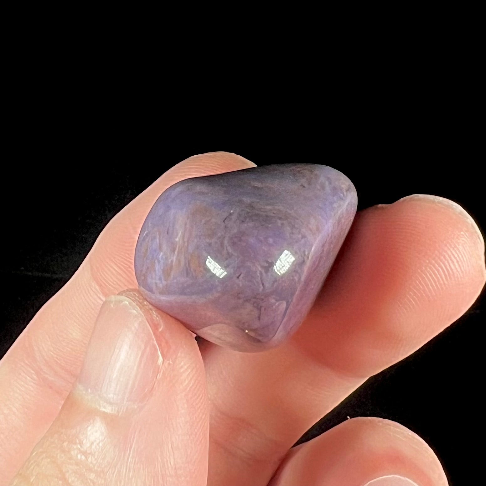 A tumbled turkiyenite stone, commonly referred to as "Turkish purple jade."