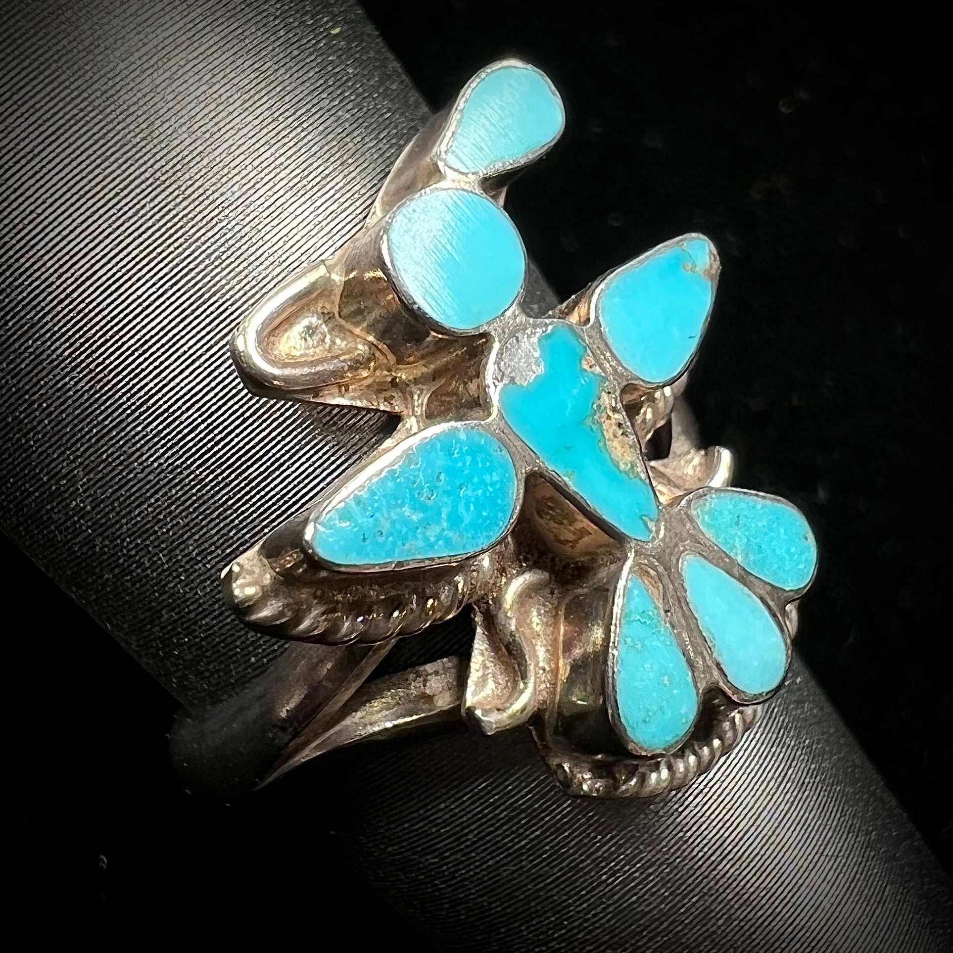 A sterling silver and turquoise inlay ring.  The ring is in the shape of a Native American thunderbird.