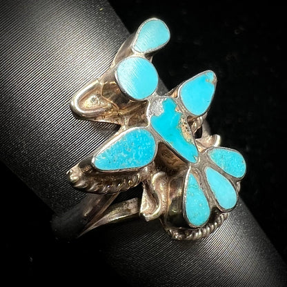 A sterling silver and turquoise inlay ring.  The ring is in the shape of a Native American thunderbird.