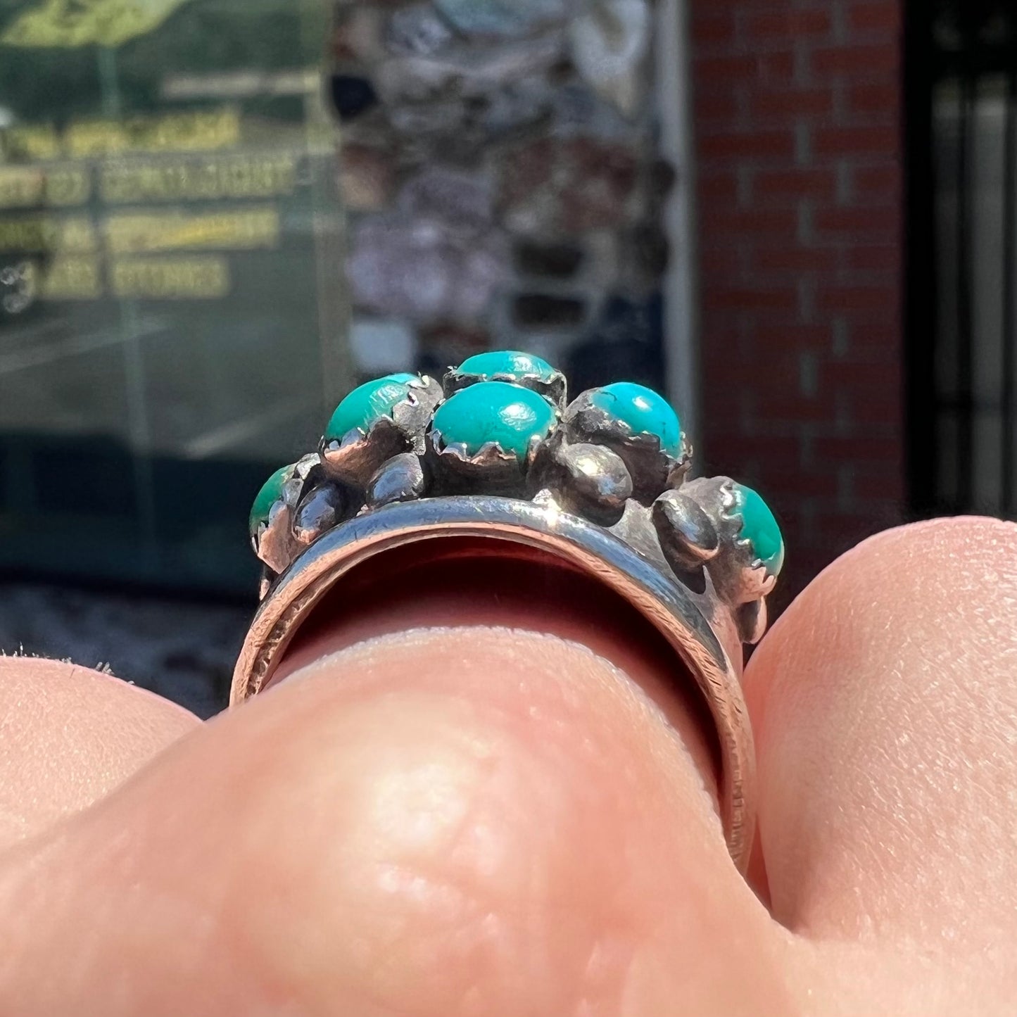 A handmade, unisex Hopi silver ring set with 14 round turquoise cabochons.