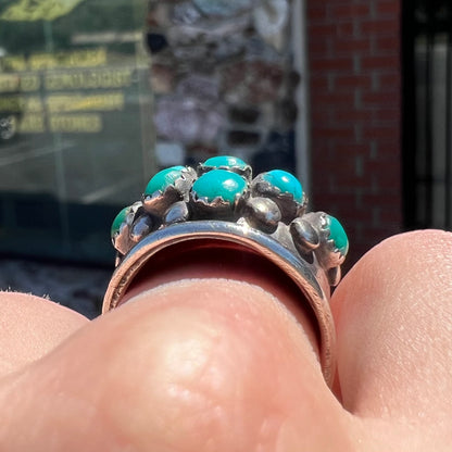 A handmade, unisex Hopi silver ring set with 14 round turquoise cabochons.