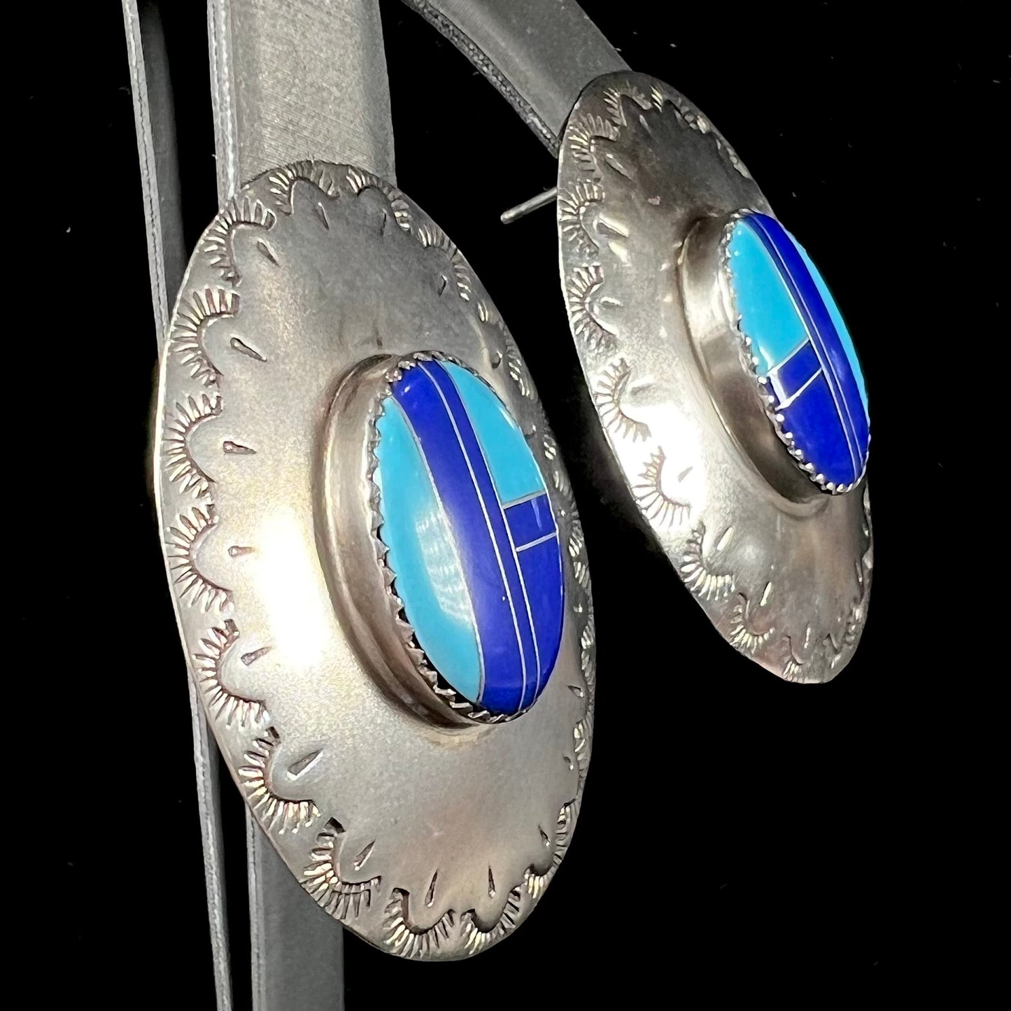 A pair of sterling silver concho earrings set with lapis lazuli and turquoise stone inlay.