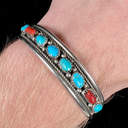 A silver ladies' turquoise and coral cuff bracelet, handmade by Navajo artist, John Delvin.