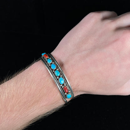 A silver ladies' turquoise and coral cuff bracelet, handmade by Navajo artist, John Delvin.