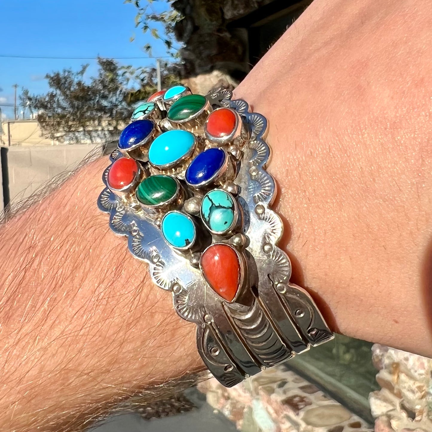 A sterling silver ladies' Navajo cuff bracelet set with turquoise, malachite, lapis lazuli, and coral stones.