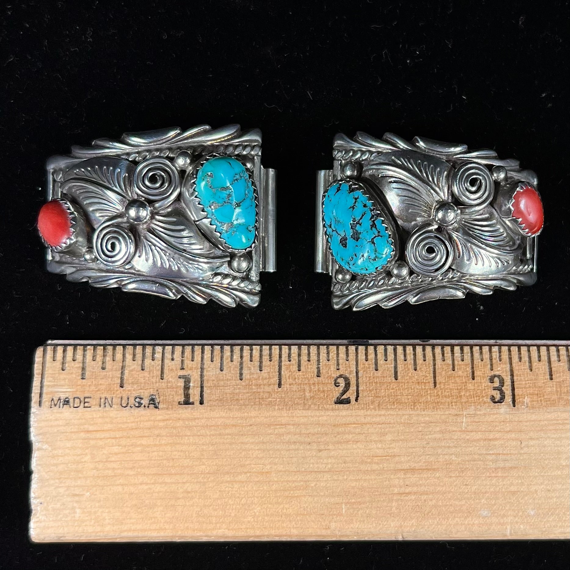 A pair of sterling silver watch cuffs set with turquoise and coral stones.
