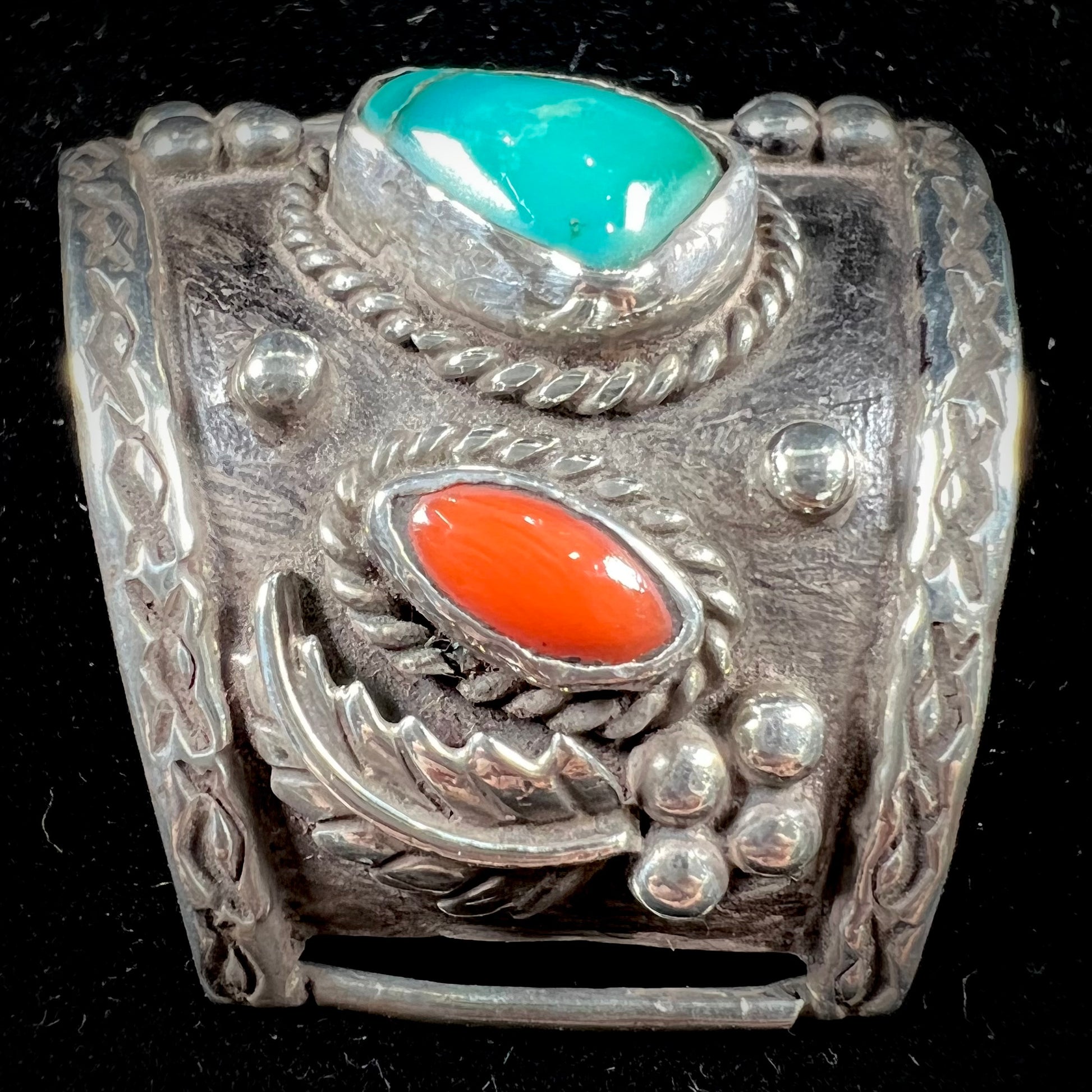 A pair of Navajo made sterling silver watch cuffs set with turquoise and coral stones.