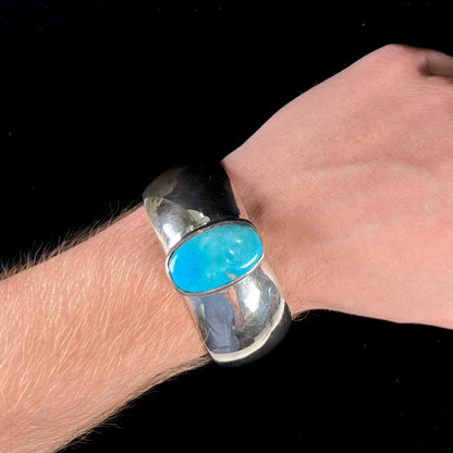 A unisex sterling silver cuff bracelet set with a barrel cabochon cut turquoise from Sleeping Beauty Mine, Arizona.