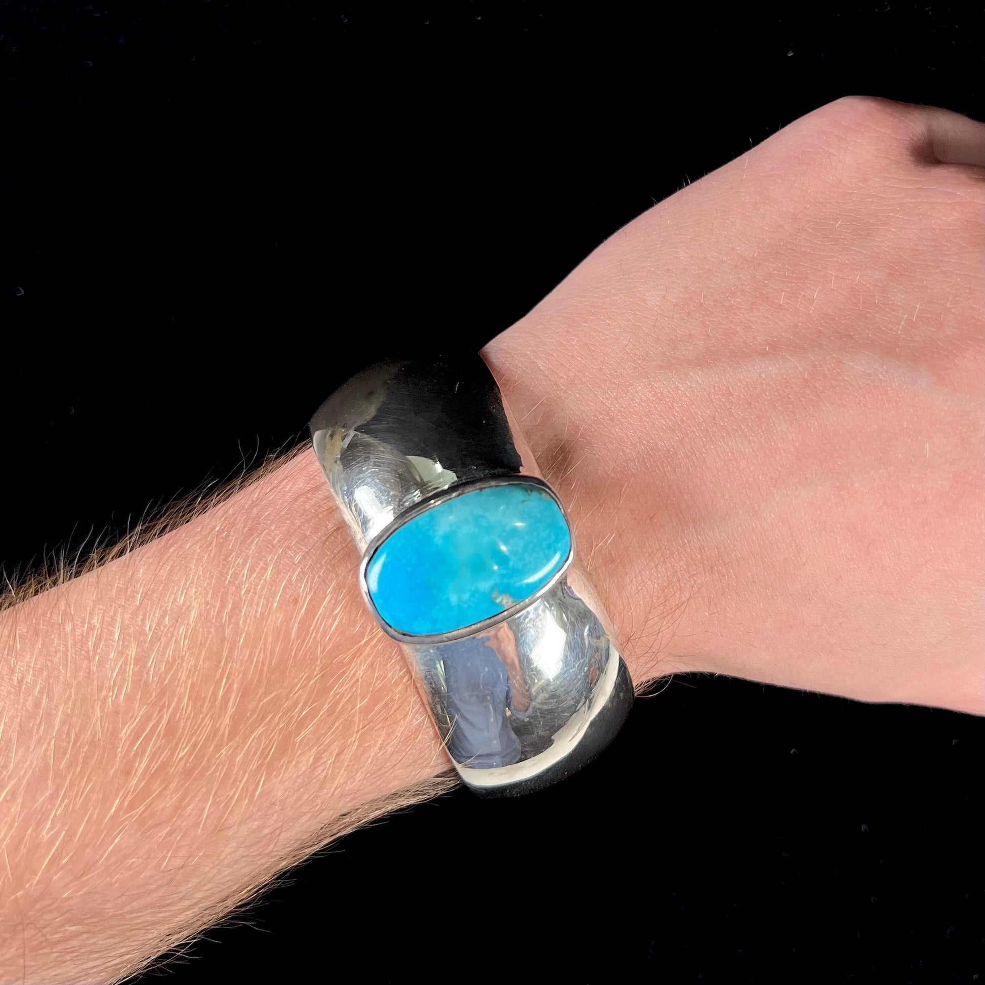 A unisex sterling silver cuff bracelet set with a barrel cabochon cut turquoise from Sleeping Beauty Mine, Arizona.