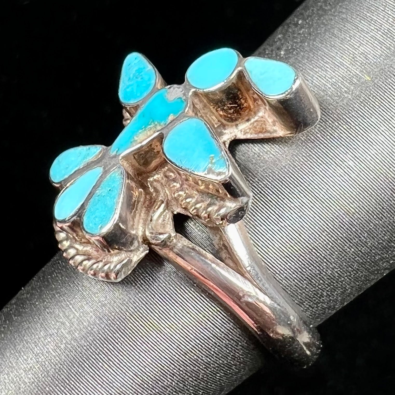 A sterling silver and turquoise inlay ring.  The ring is in the shape of a Native American thunderbird.
