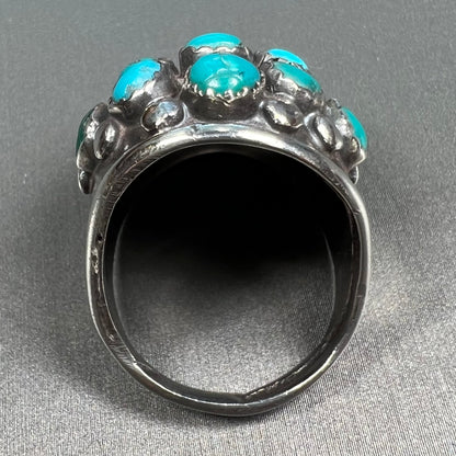 A handmade, unisex Hopi silver ring set with 14 round turquoise cabochons.