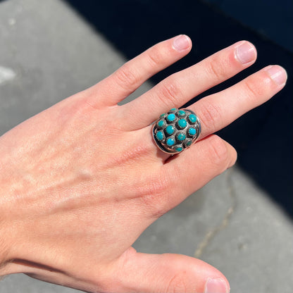 A handmade, unisex Hopi silver ring set with 14 round turquoise cabochons.