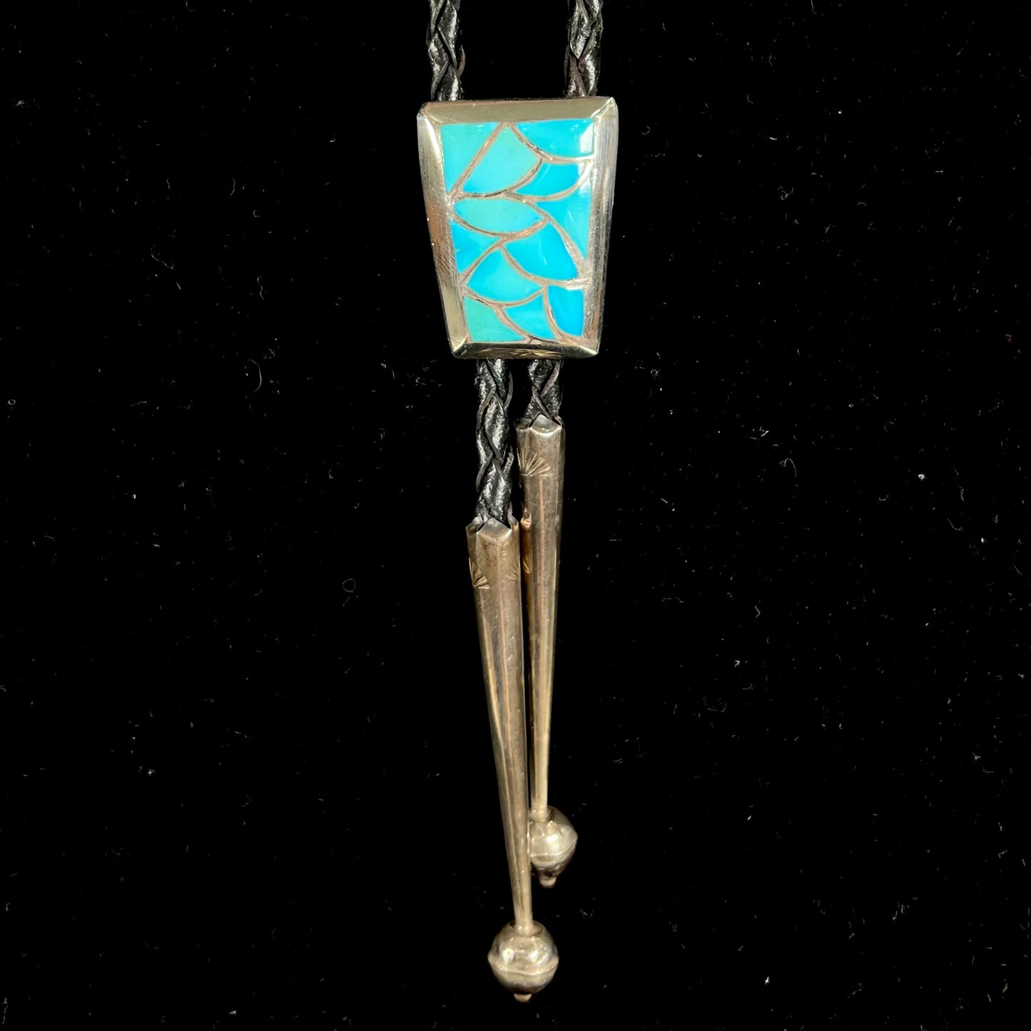 A silver turquoise inlay bolo tie handmade by Navajo artist, Lillian Fernando.