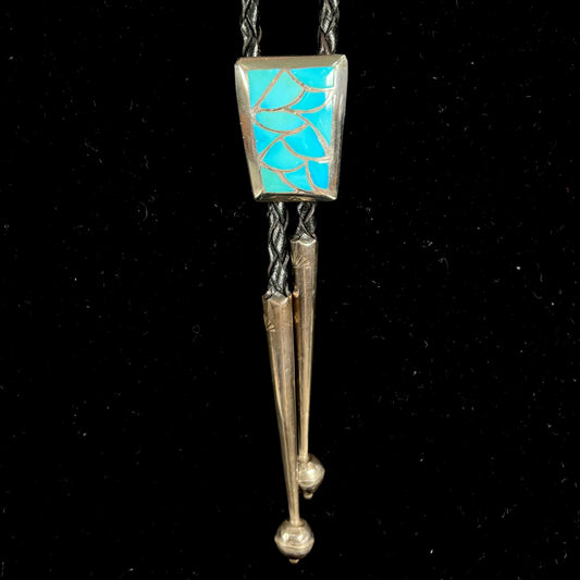 A silver turquoise inlay bolo tie handmade by Navajo artist, Lillian Fernando.