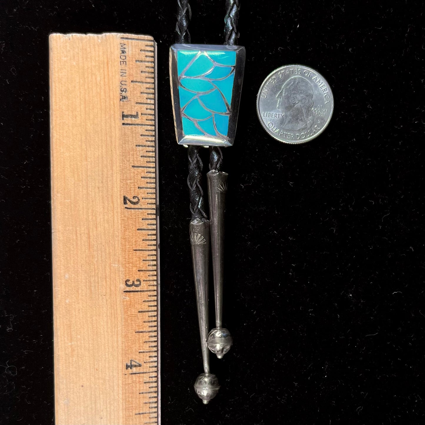 A silver turquoise inlay bolo tie handmade by Navajo artist, Lillian Fernando.