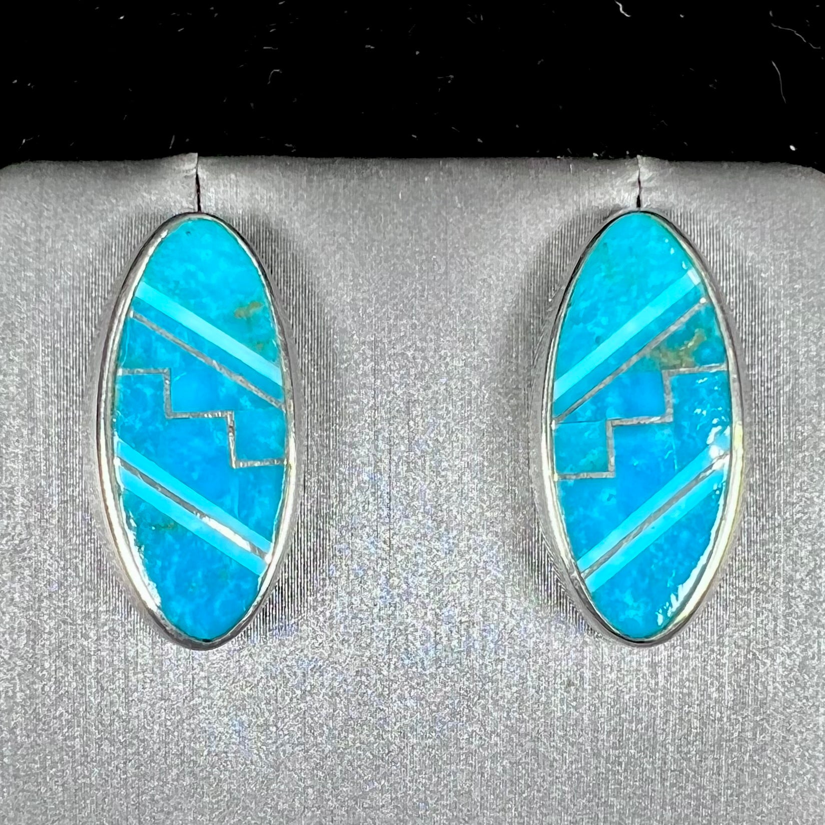 A pair of sterling silver turquoise inlay earrings, handmade by the Zuni artist.