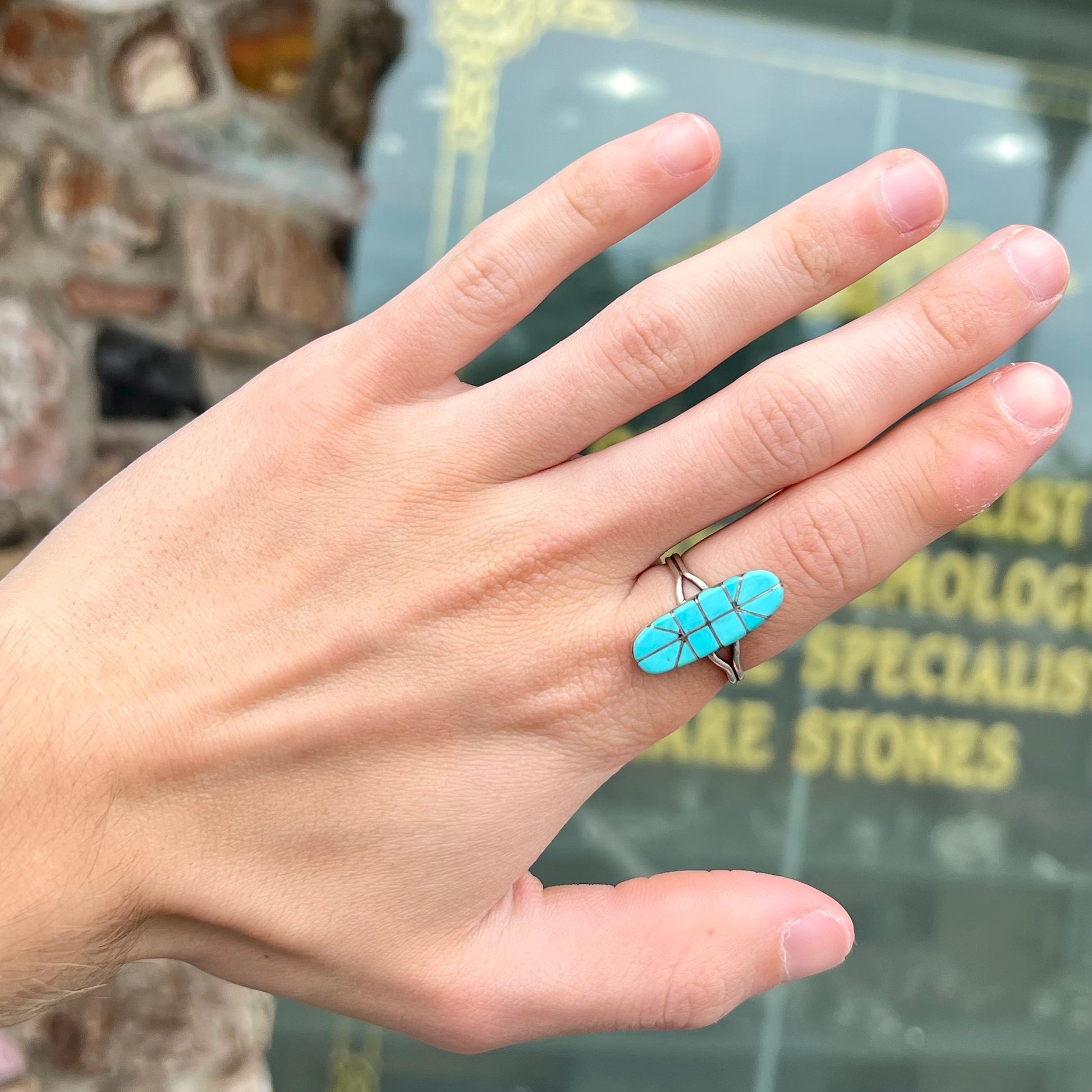 A handmade silver turquoise ring inlaid with six pieces of Sleeping Beauty turquoise.  The back of the ring is signed "FT".