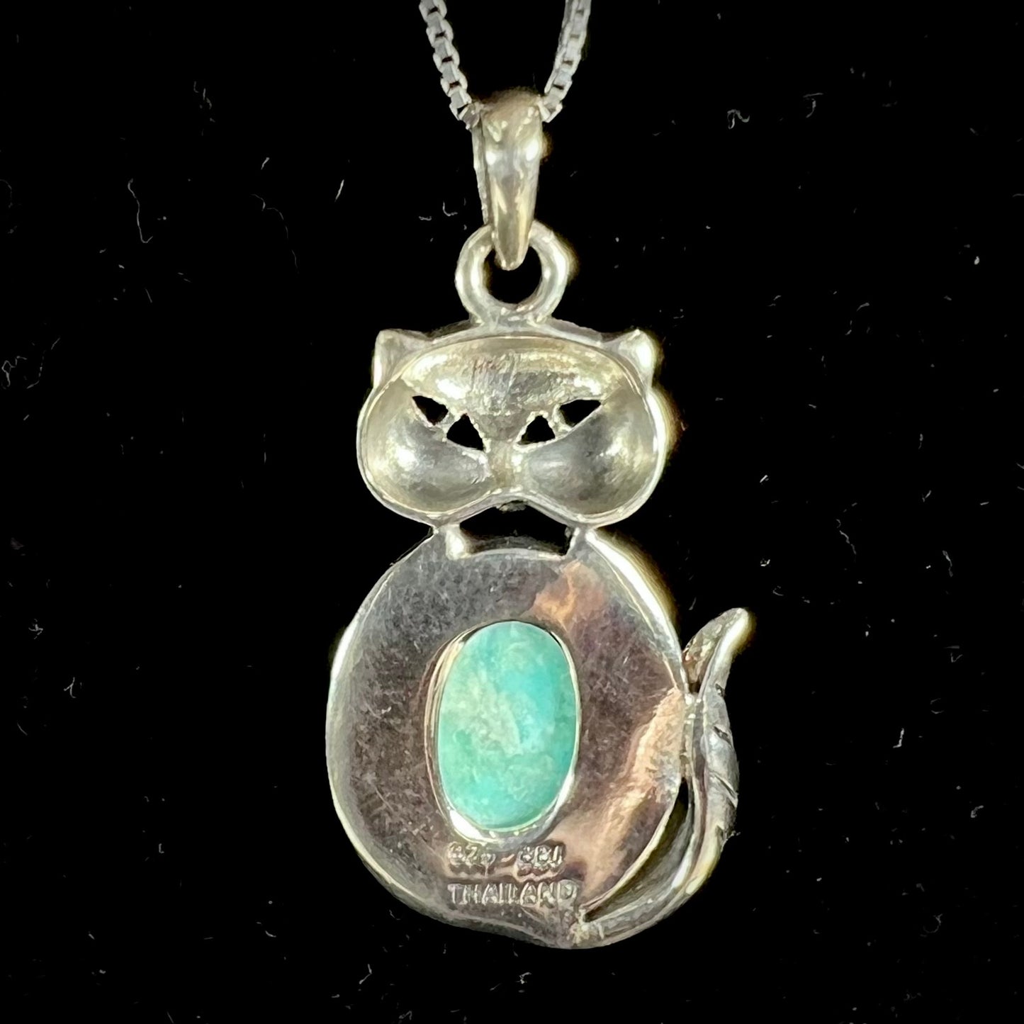 A sterling silver cat necklace set with an oval cut Sleeping Beauty turquoise stone.