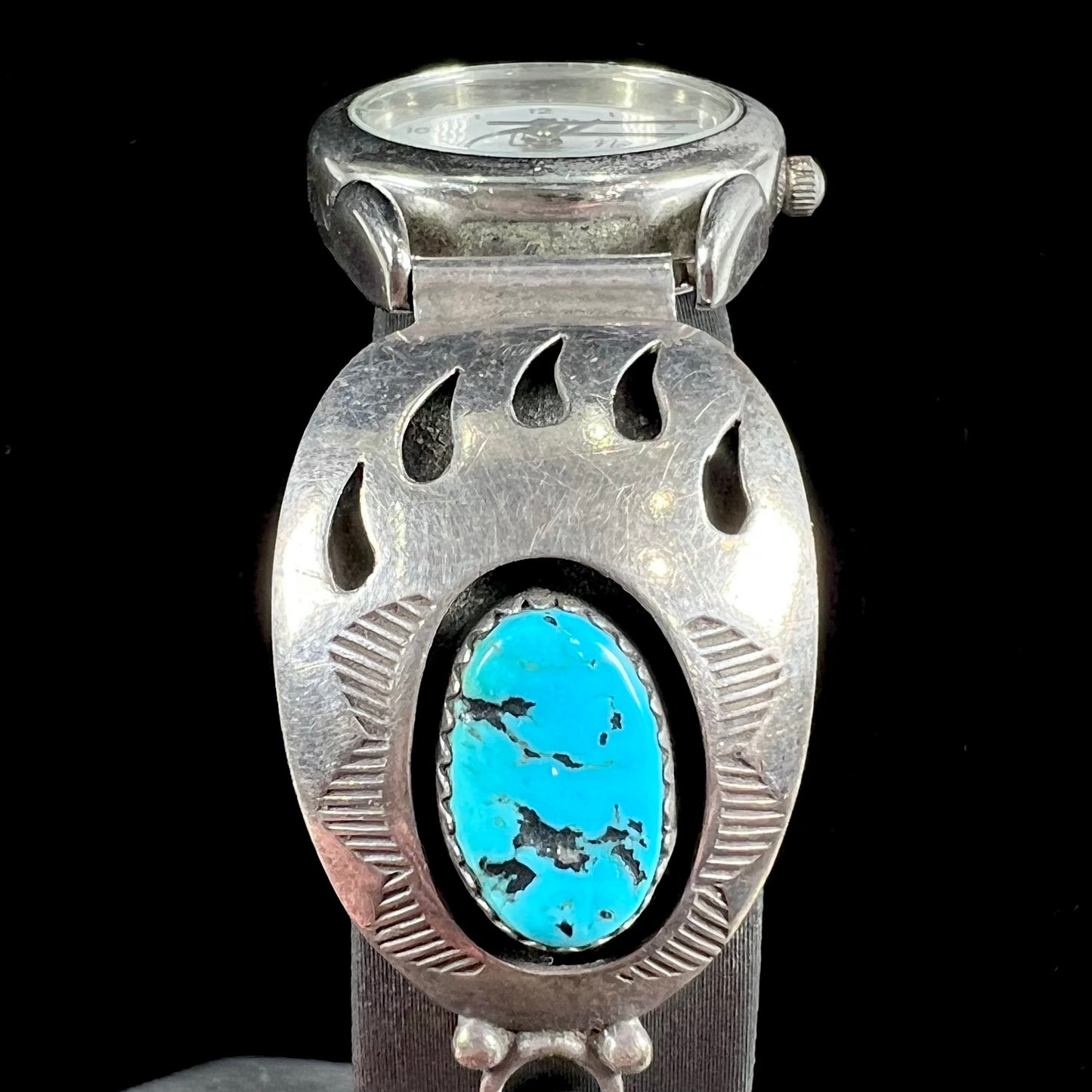 A watch set with two turquoise stones handmade by Navajo artists Arnold and Carleena Goodluck.