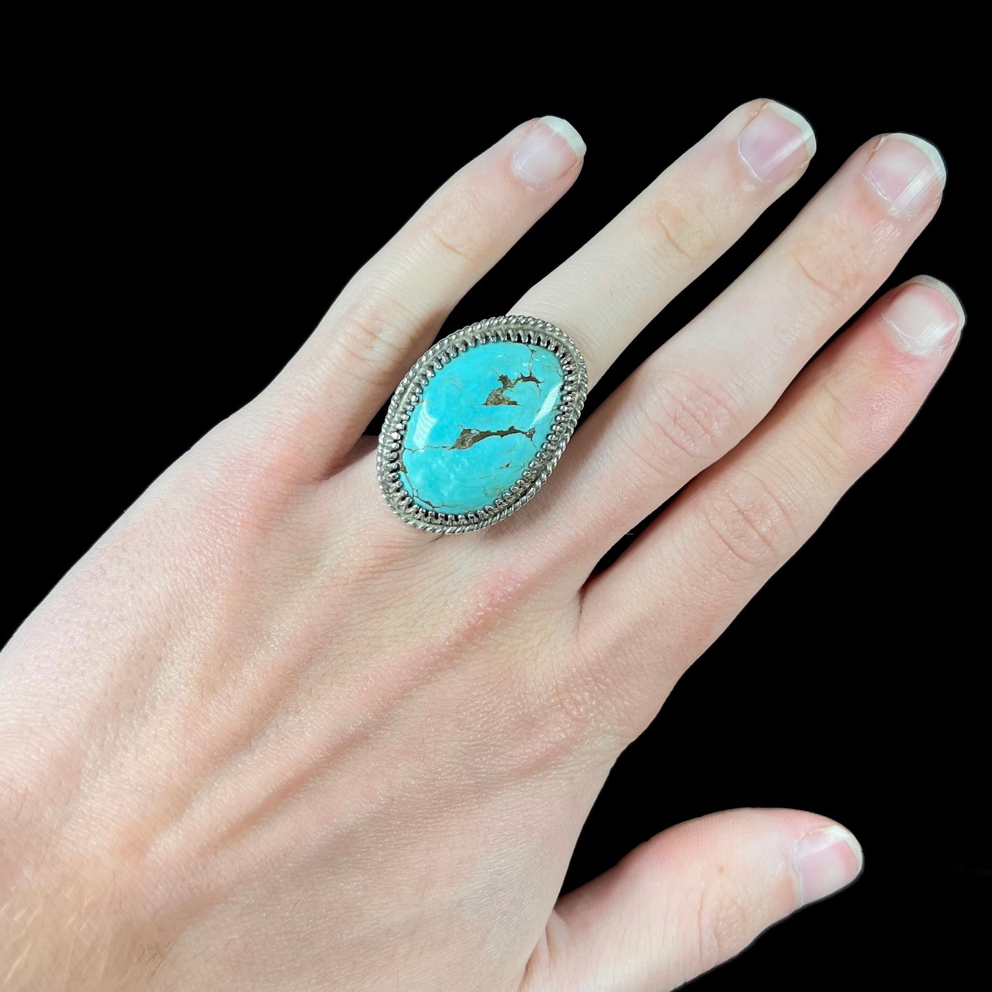 A sterling silver rope design ring set with a turquoise stone from Pilot Mountain Mine, Nevada.
