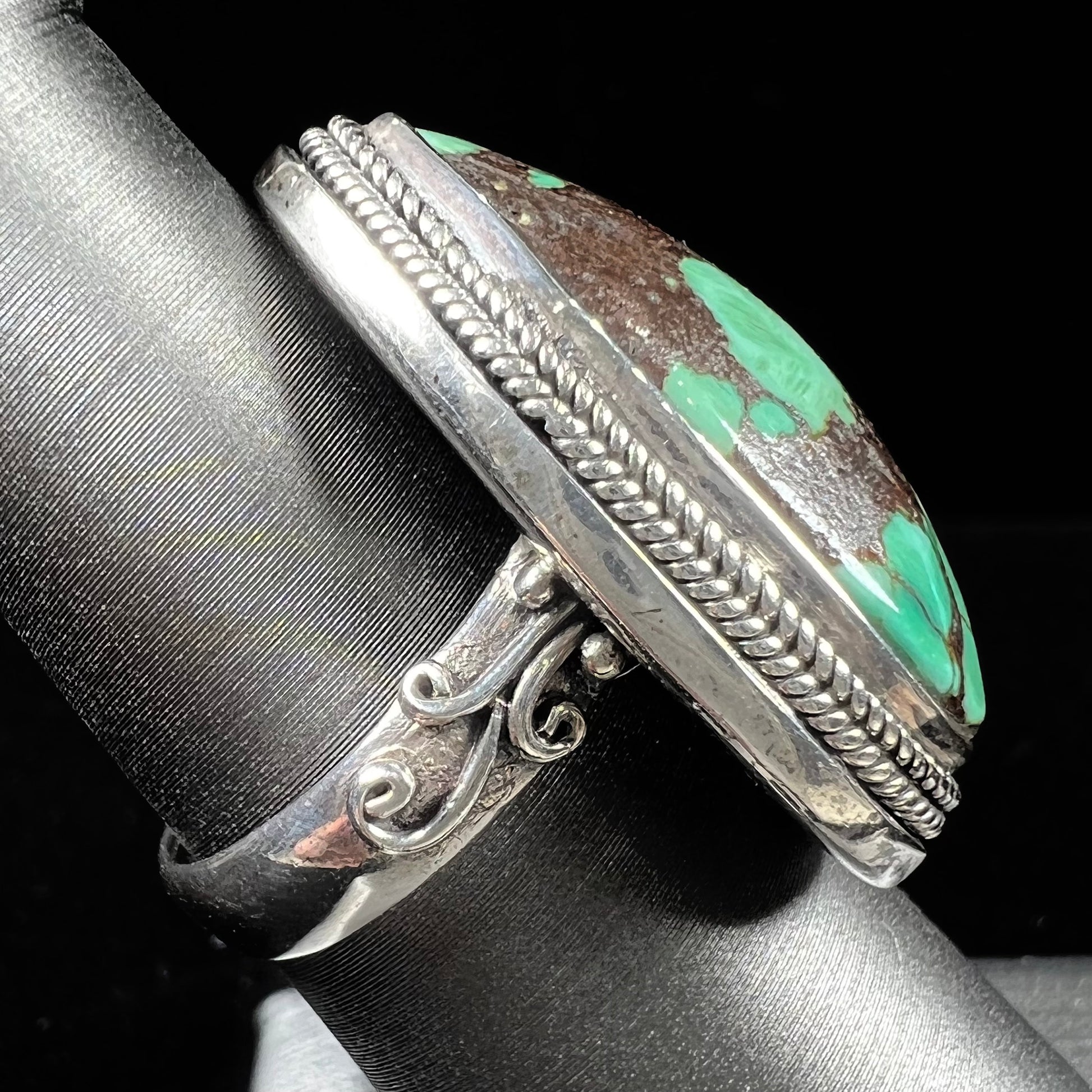 A sterling silver ring bezel set with a green spotted turquoise stone from Carico Lake, Nevada.