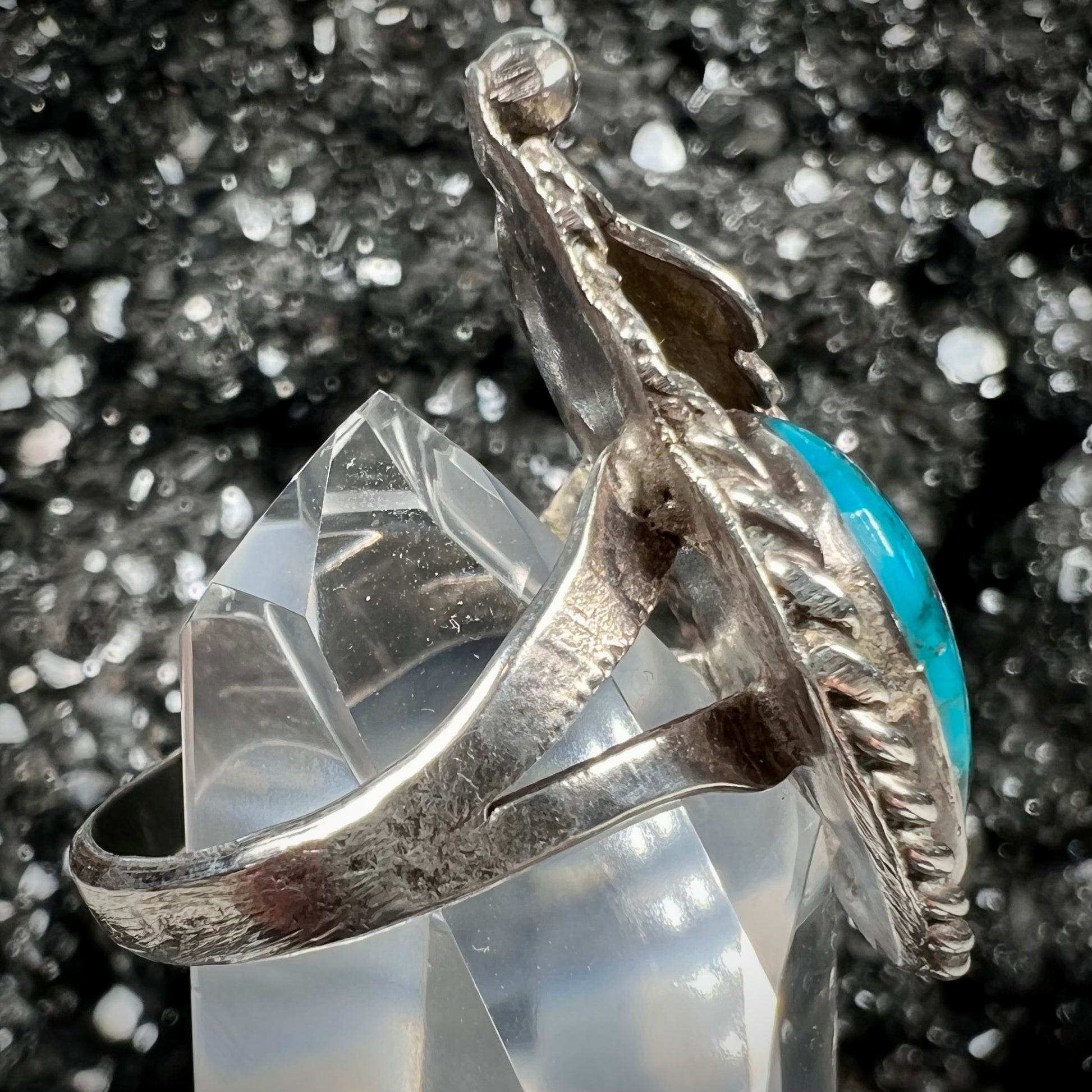 A handmade Navajo men's turquoise ring.  The ring is made with wire and carved silver.