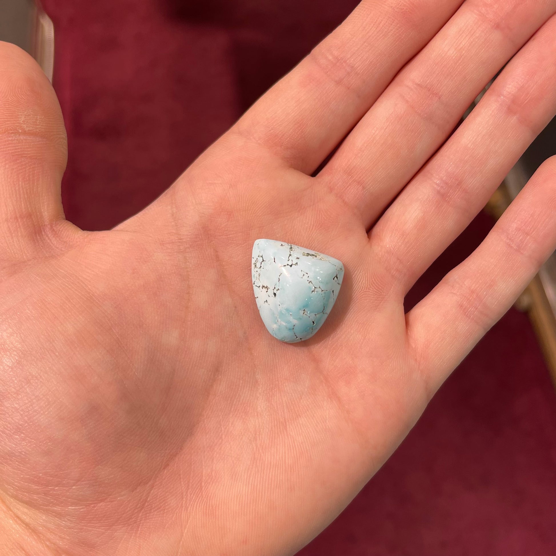 A loose, freeform cabochon cut light blue turquoise stone from Sleeping Beauty Mine, Arizona.