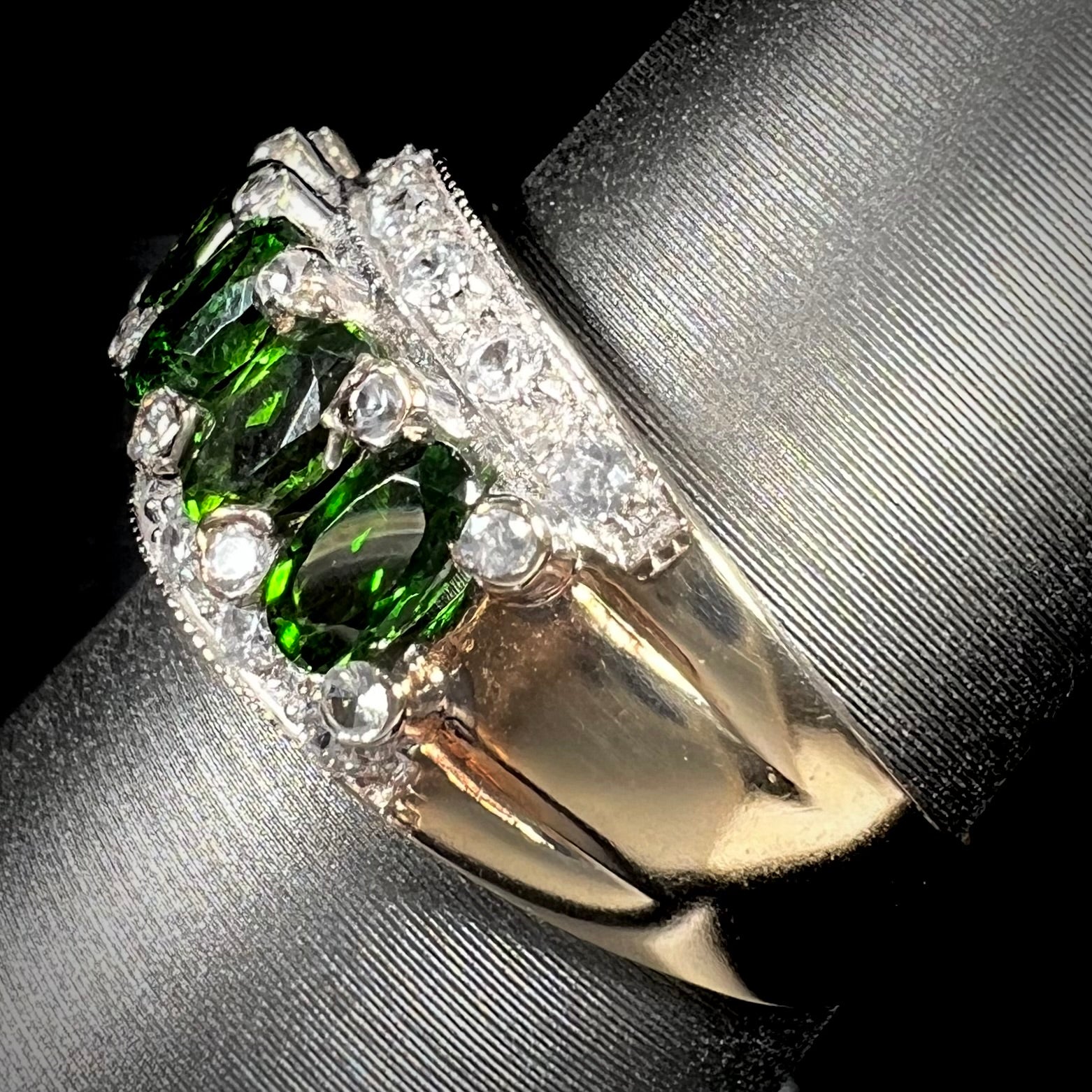 A ladies' two-tone white and yellow gold ring set withseven oval cut chrome diopside stones and cubic zirconia accents.