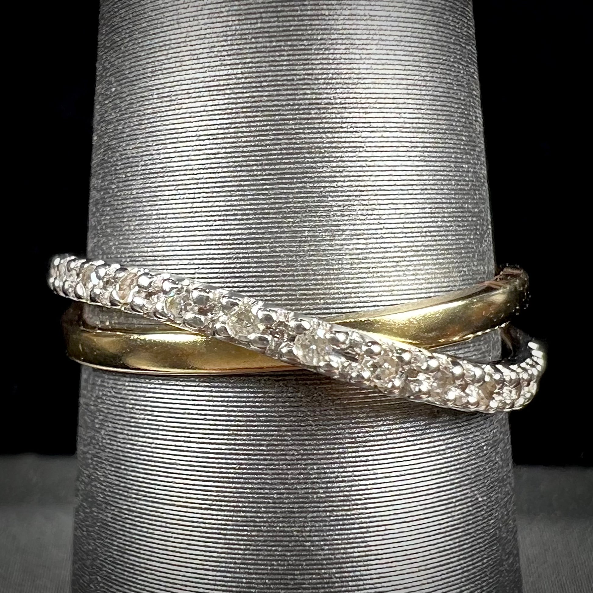 A ladies' two tone yellow and white gold twisted shank ring pave set with round single cut diamonds.