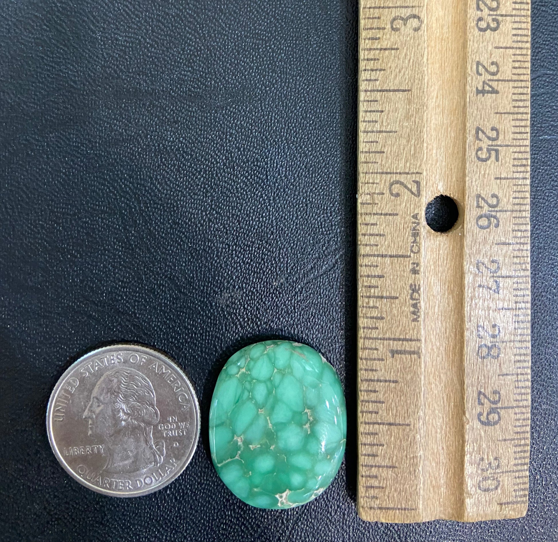A loose, oval cabochon cut variscite stone from Utah, USA.