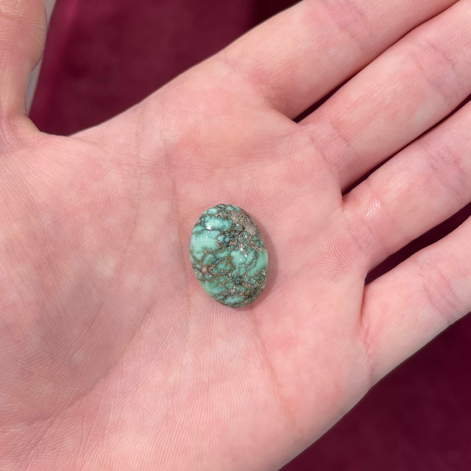 A loose, oval cabochon cut variscite stone from Utah, USA.