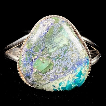 A handmade sterling silver cuff bracelet set with a single stone formed from variscite, chrysocolla, and azurite.
