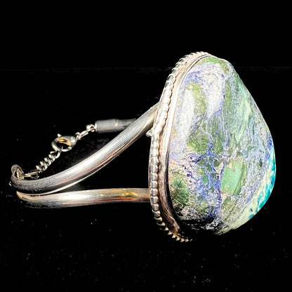 A handmade sterling silver cuff bracelet set with a single stone formed from variscite, chrysocolla, and azurite.