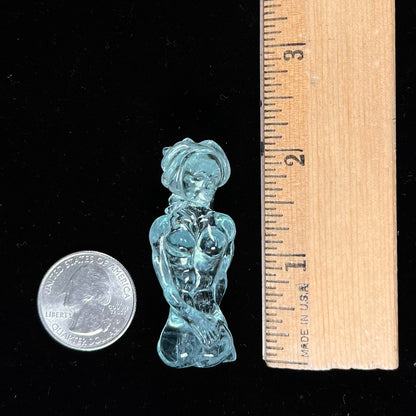 A stone woman figure carved from a blue aquamarine crystal.  The piece resembles Venus Gummi de Milo.