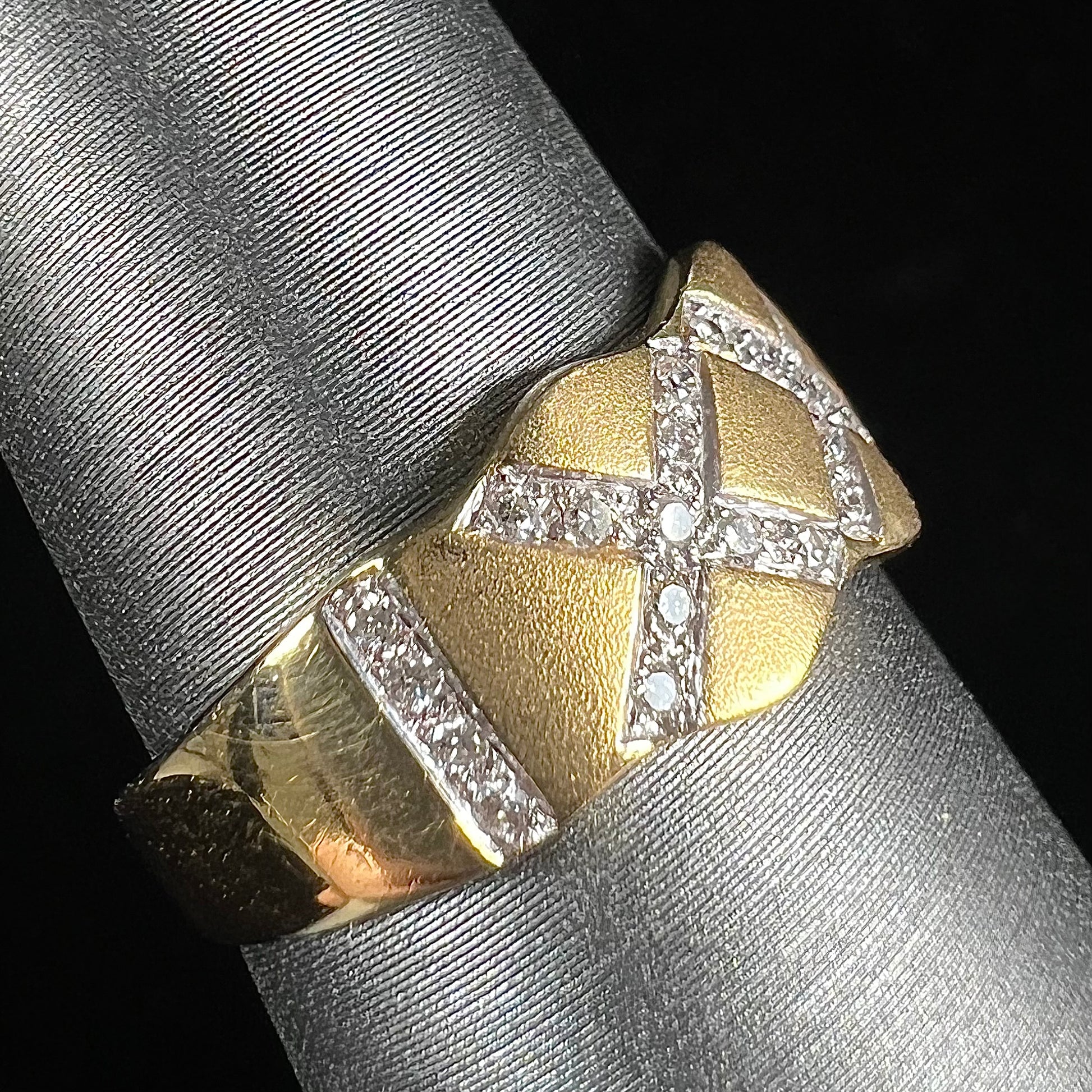 An 18kt yellow gold ring with three "X" shapes pave set with round diamonds.