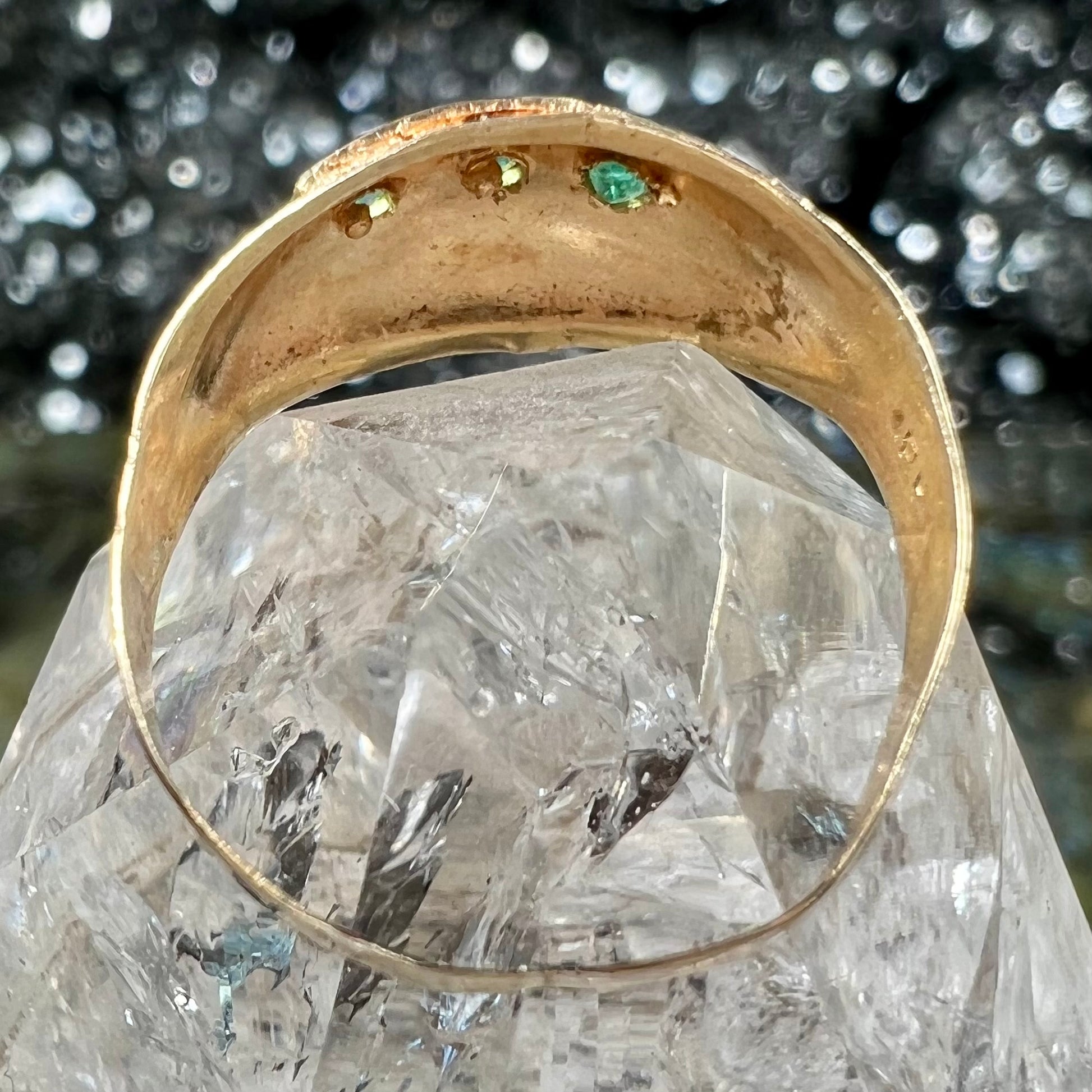 A 1920's style yellow gold three stone round cut emerald ring.