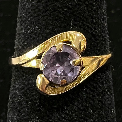 A vintage 1960's yellow gold ring set with a round synthetic purple alexandrite.  The prongs are worn.
