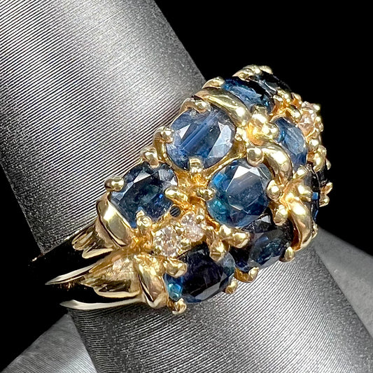 A vintage ladies' blue sapphire and diamond cluster ring cast in yellow gold.