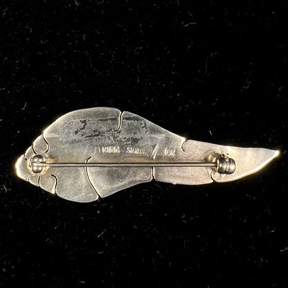 A two-tone silver and gold feather pin, handmade by Isleta Pueblo Indian artist, Michael Kirk.