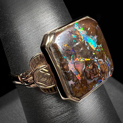An antique yellow gold boulder opal ring.  The stone is a sqaure cut natural opal from Quilpie, Australia.