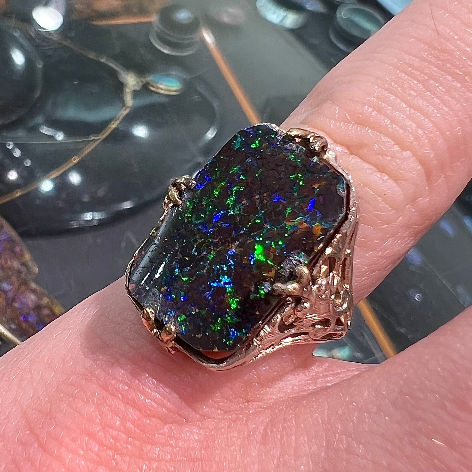 A vintage, white gold filigree unisex ring set with a black Koroit boulder opal.