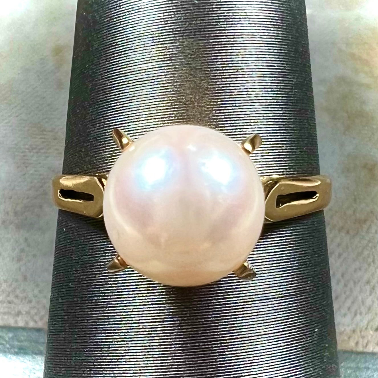 Round white pearl with pink overtones set in a vintage 18k yellow gold ring.