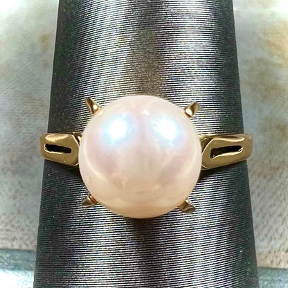 Round white pearl with pink overtones set in a vintage 18k yellow gold ring.