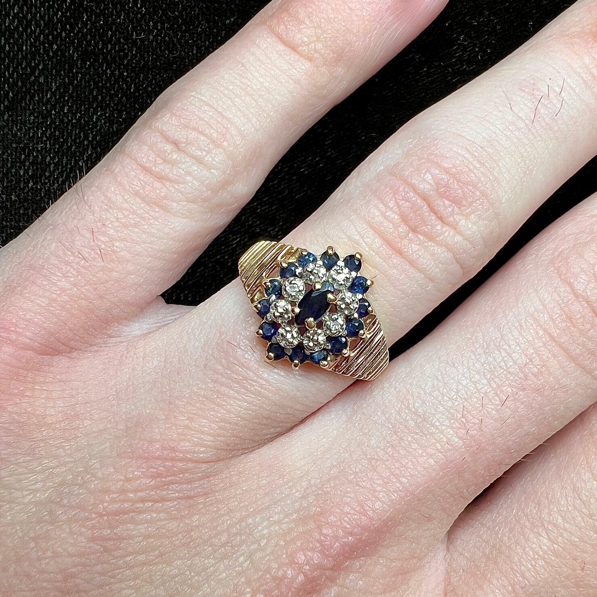 A yellow gold cluster halo ring set with blue sapphire and diamond halos.