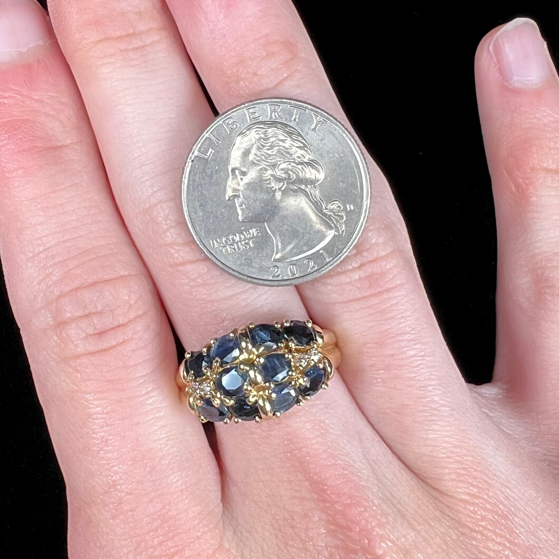 A vintage ladies' blue sapphire and diamond cluster ring cast in yellow gold.