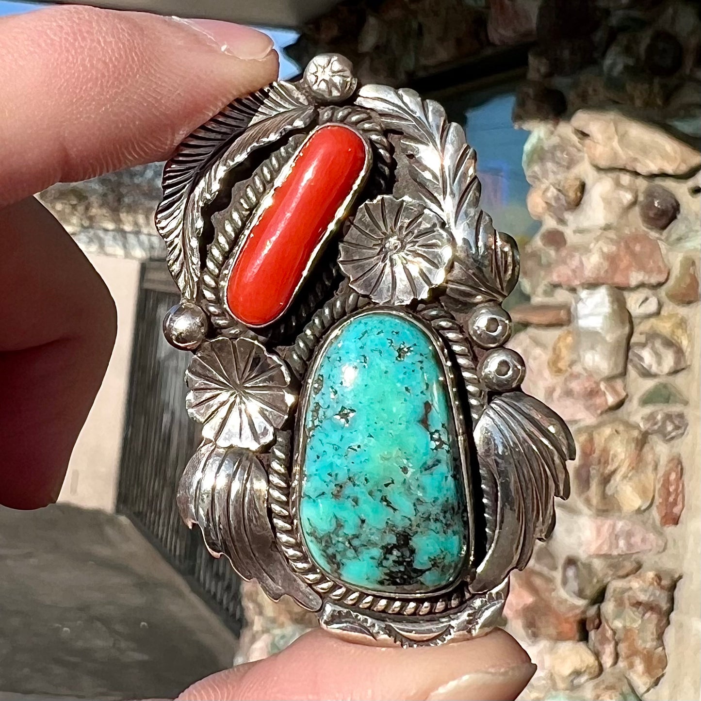 A sterling silver, 1970's Navajo pendant set with Kingman turquoise and coral stones, handmade by artist Angela Lee.