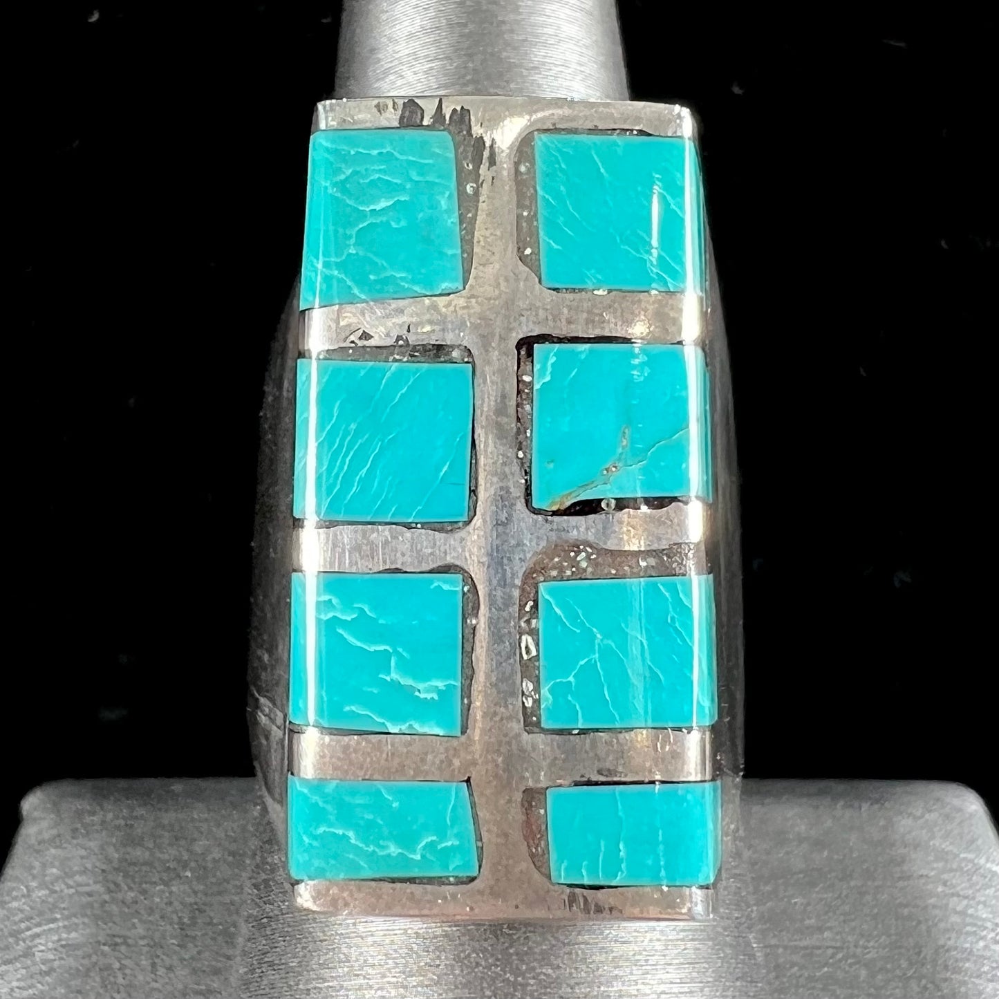 A men's sterling silver turquoise inlay ring, circa 1970.  The piece is set with 8 stones.