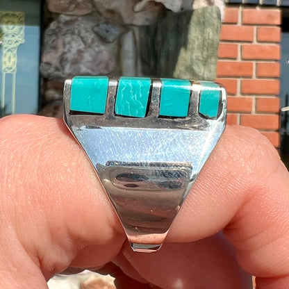 A men's sterling silver turquoise inlay ring, circa 1970.  The piece is set with 8 stones.