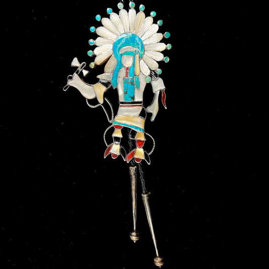 A Zuni Indian-made bolo tie featuring the motif of a kachina, inlaid with natural turquoise, mother of pearl, jet, and jasper stones.