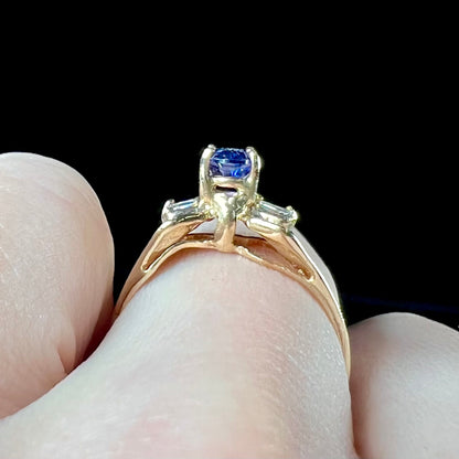 A natural blue sapphire and diamond baguette ring cast in yellow gold.